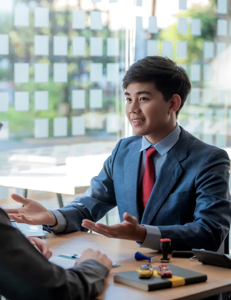 Consultant in a suit talking with a client across a desk