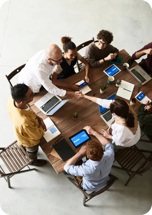 Team meeting around a table with laptops